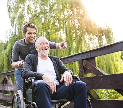 Man Pushing Older Man In Wheelchair
