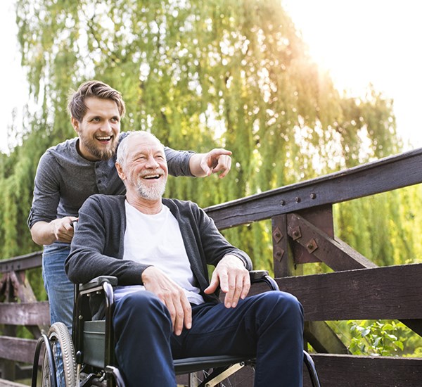 Man Pushing Older Man In Wheelchair