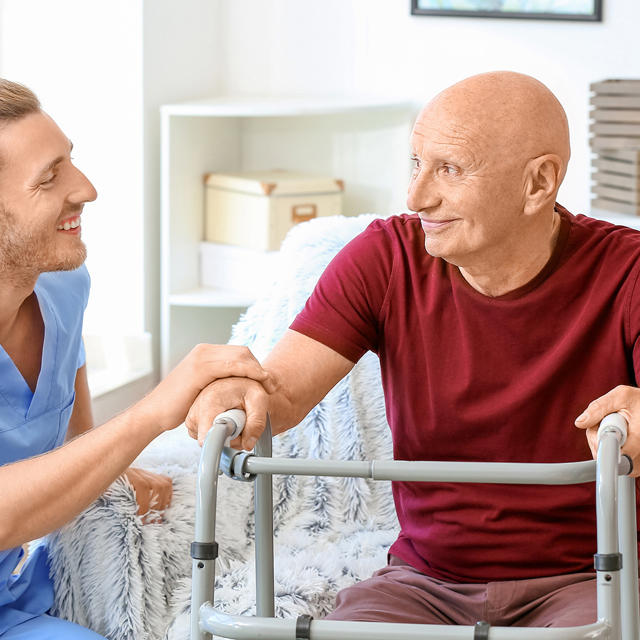 Man And Care Worker In Living Room Zimmer Frame