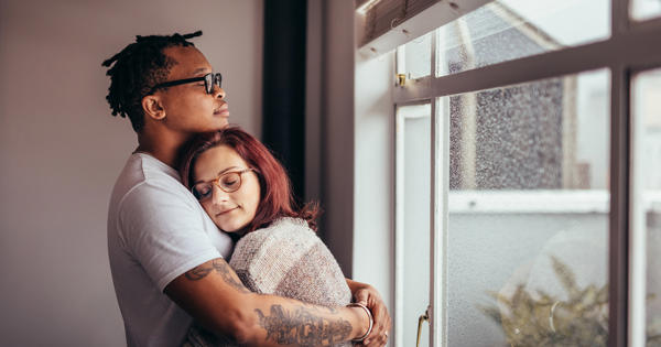Young Couple Hugging Near Window