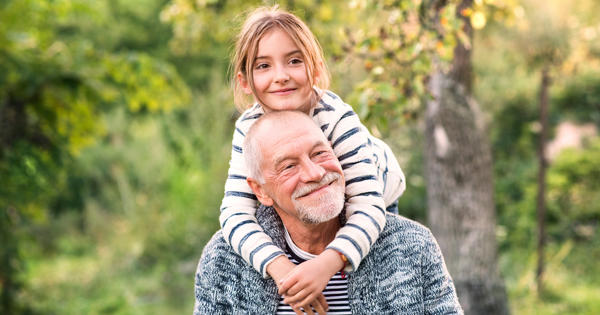 Grandad Carrying Grandaughter On Shoulders