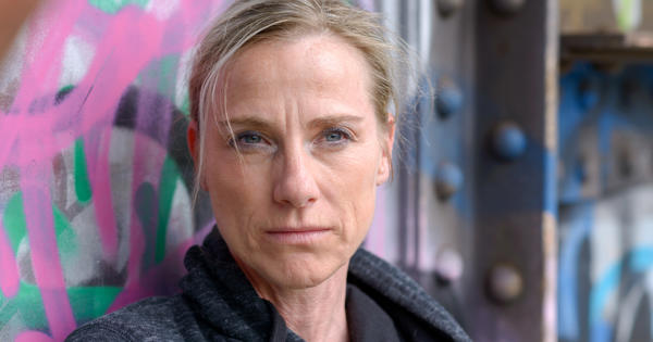 Woman Wearing Hoodie Against Graffiti Wall